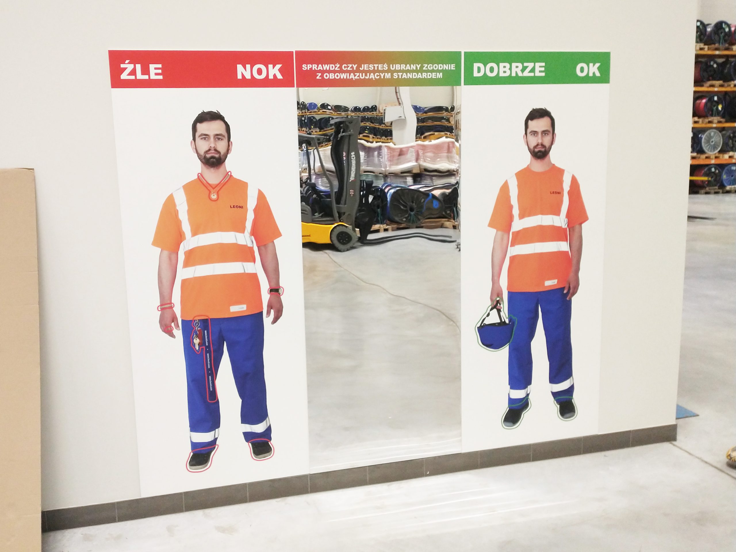 Tablica z lustrem, przedstawiająca jak powinien być ubrany pracownik